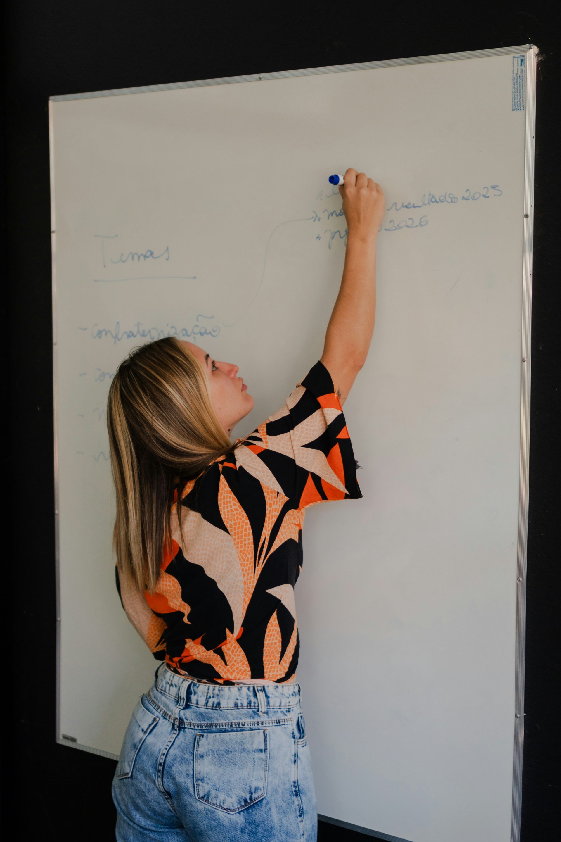 Woman writing on a whiteboard with a marker